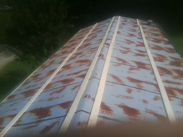 Rusted metal roof panels with new wood purlins before replacement — Storm Damage Roof Repair in Havensville by Roofing Brothers